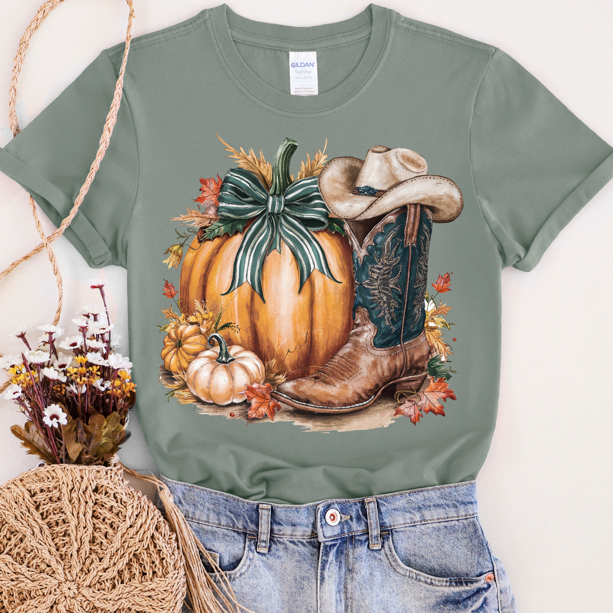 Green t-shirt with a pumpkin and cowboy boot design on a white background