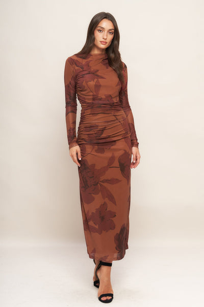 Woman wearing a brown floral dress against a white background
