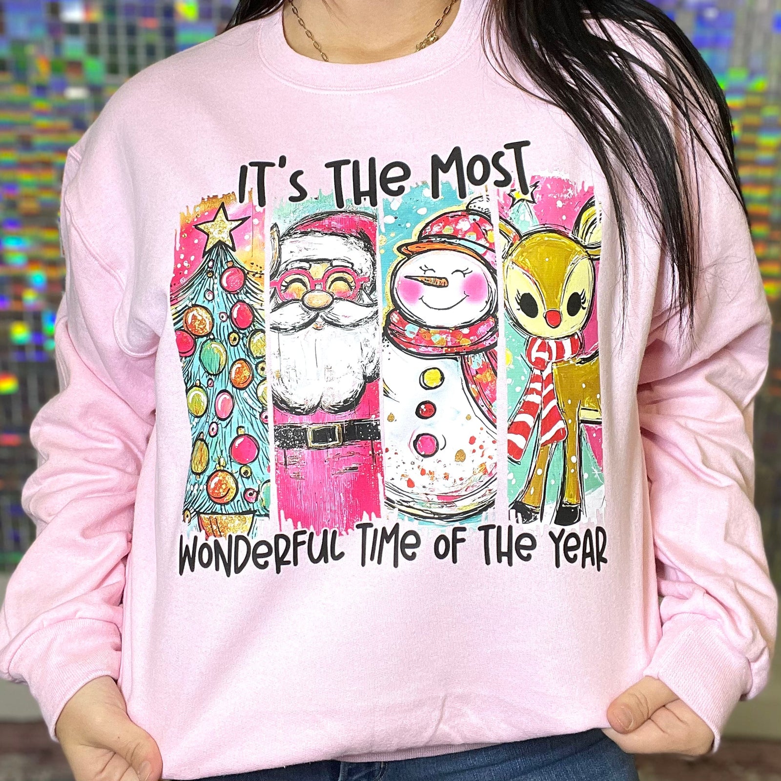 Pink sweatshirt with Christmas-themed design featuring Santa, snowman, and reindeer.