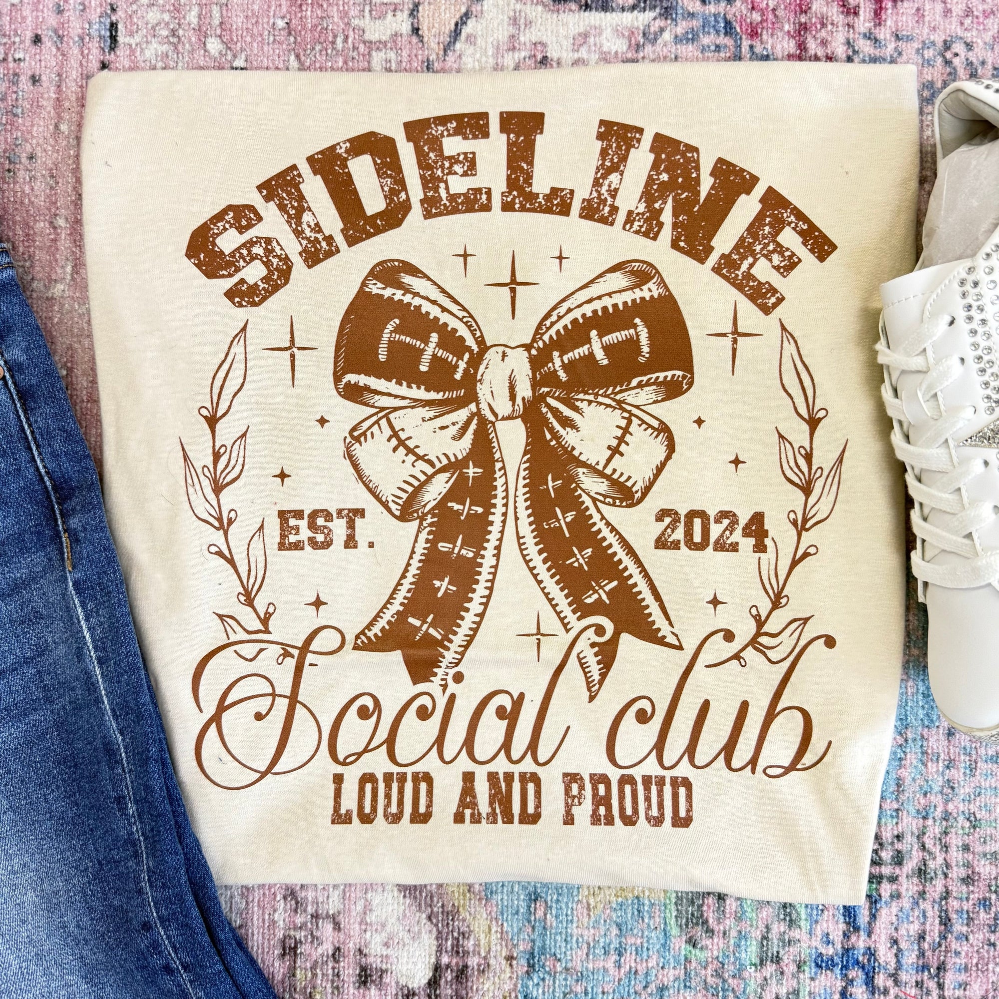 Canvas bag with 'Sideline Social Club' design featuring a football bow on a textured surface.