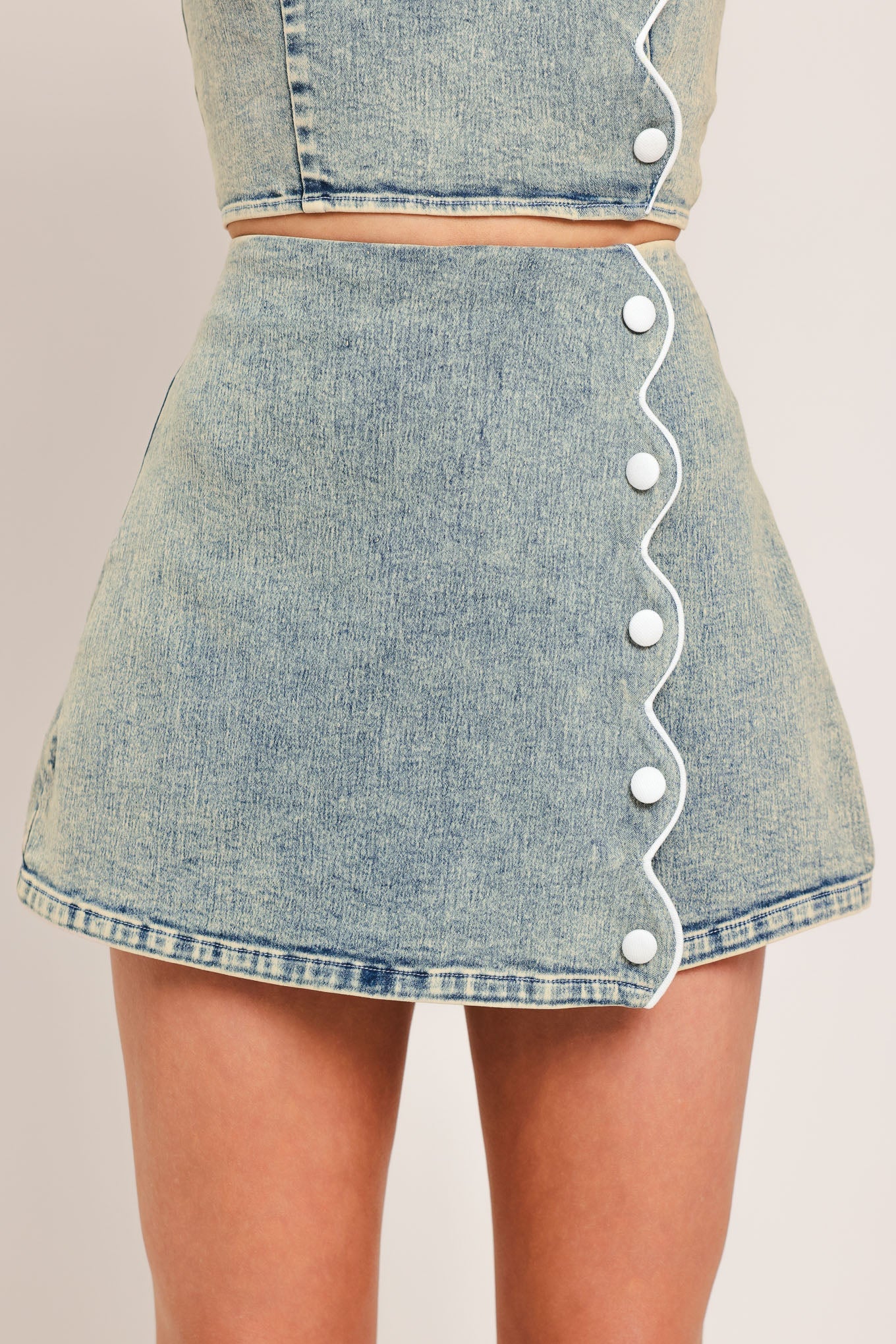 Denim skirt with button details on a plain background
